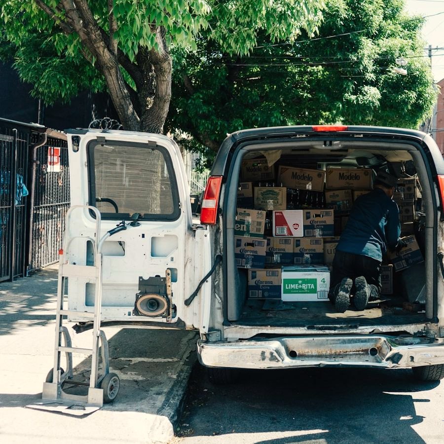 A working van with its rear doors open, loaded with equipment