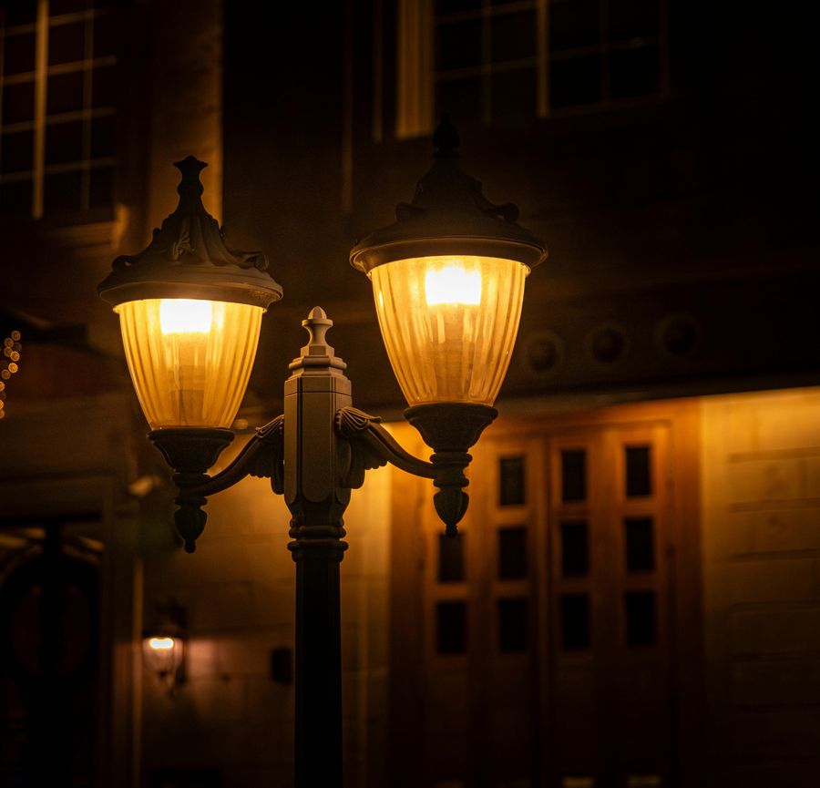Two lit street lamps at night